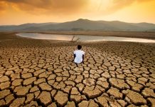 Man sitting on dry land as a result of climate change