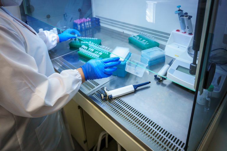 Scientist in lab with COVID-19 equipment