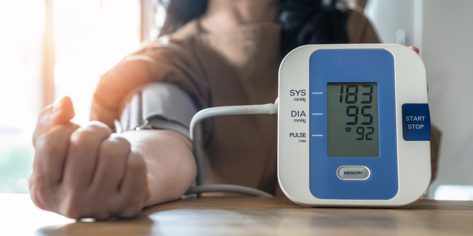 woman taking her blood levels, indicating high blood pressure on monitor, risk of stroke