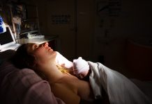 woman holding her new born baby in a doctor's office, health concept