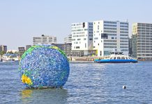 Floating globe art on the water on September 5, 2012 in Amsterdam. The art was made from plastic bottles and other junk collected around the city by Peter Singer.