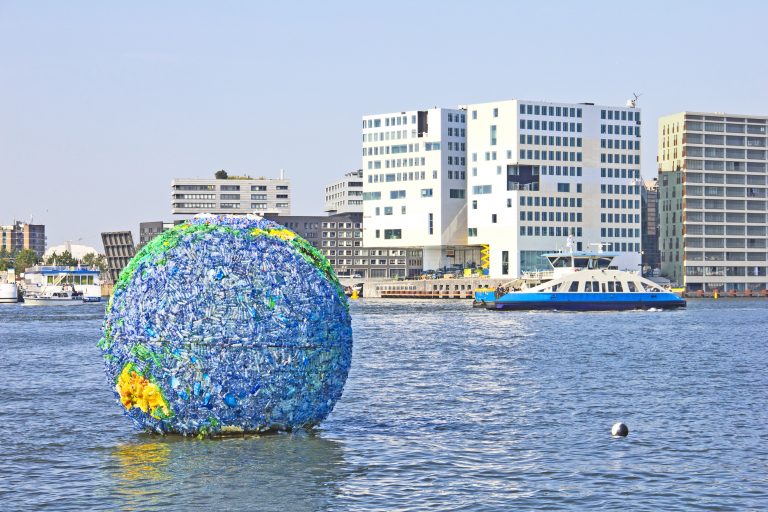 Floating globe art on the water on September 5, 2012 in Amsterdam. The art was made from plastic bottles and other junk collected around the city by Peter Singer.