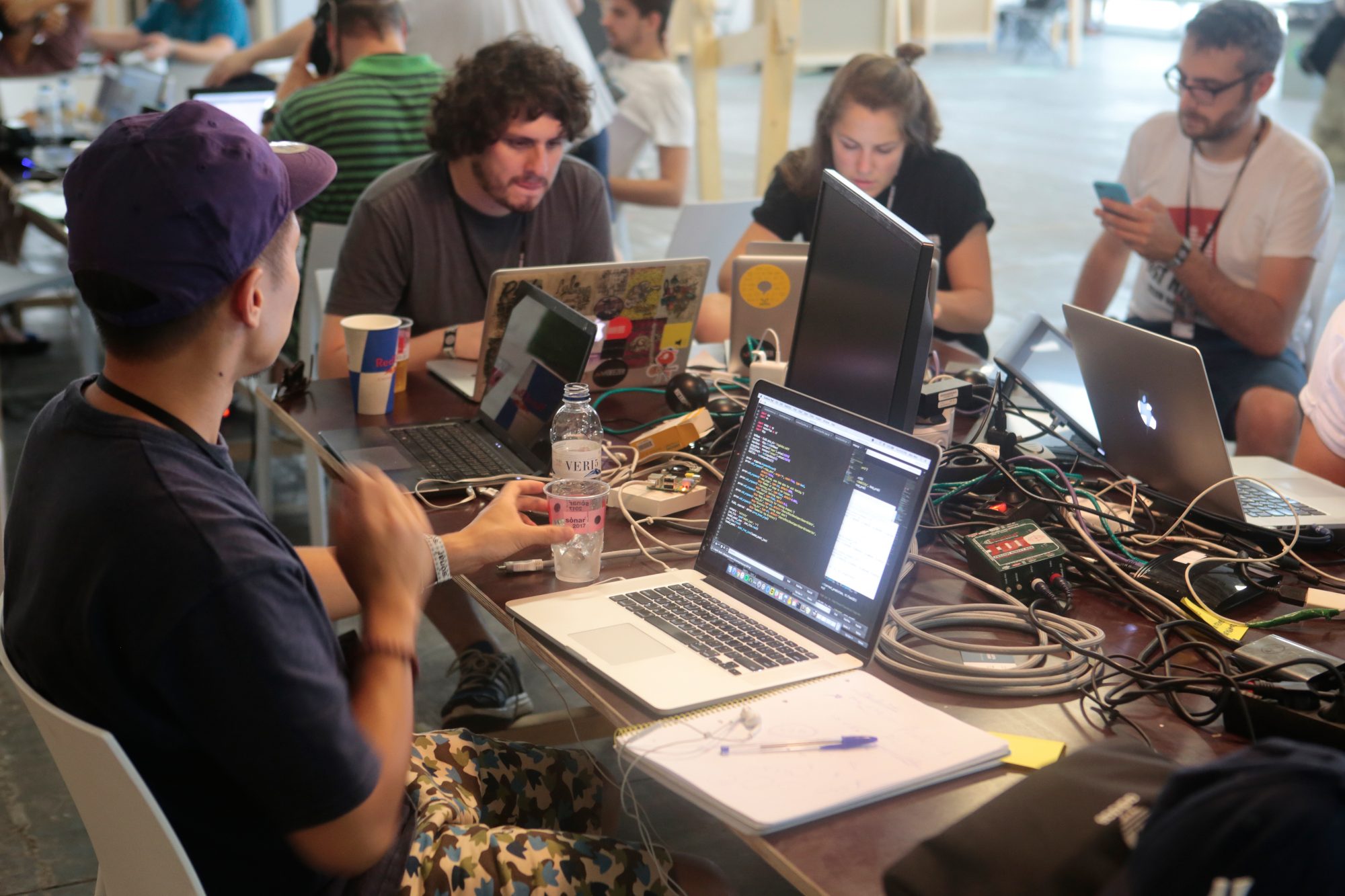 Group of IT workers on laptops sitting around table