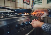 Man lighting stove with match.