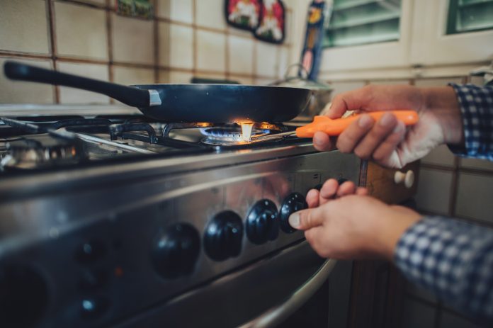 Man lighting stove with match.