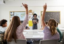 teacher shortages, picture of a teacher in a high school classroom, student asking questions