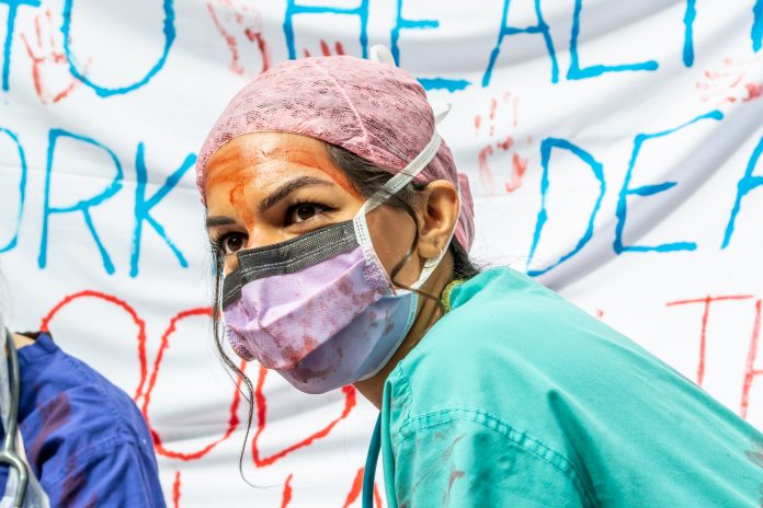 NHS covered in fake blood protesting against poor working conditions and poor pay