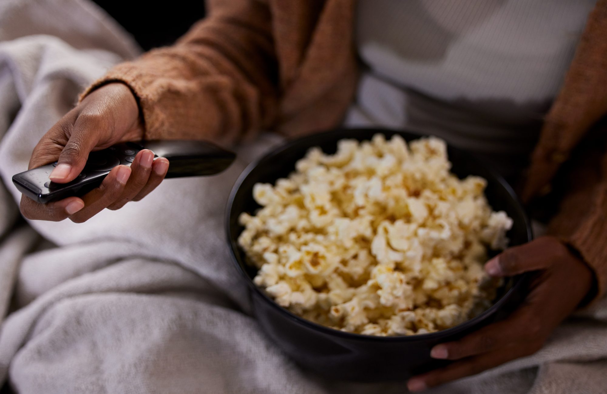 Woman binge eating popcorn whilst watching TV