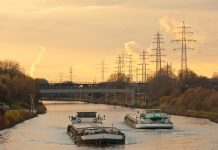 an example inland waterway transport, an image of a canal boat on a river with the sun setting