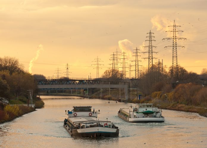 an example inland waterway transport, an image of a canal boat on a river with the sun setting
