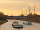 an example inland waterway transport, an image of a canal boat on a river with the sun setting