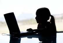 Silhouette of young girl with ponytail searching on the web