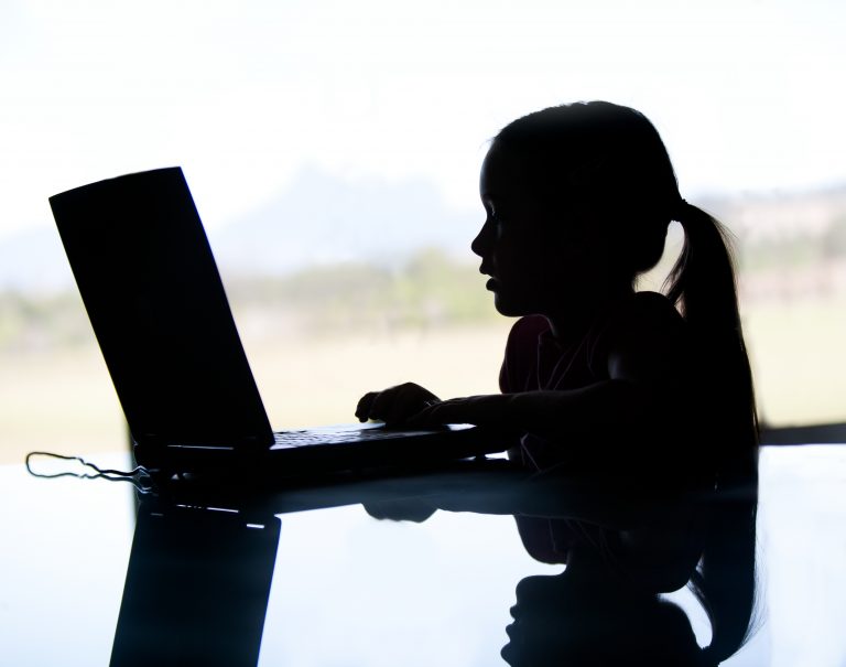 Silhouette of young girl with ponytail searching on the web