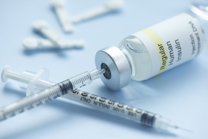 a needle injected into an insulin bottle