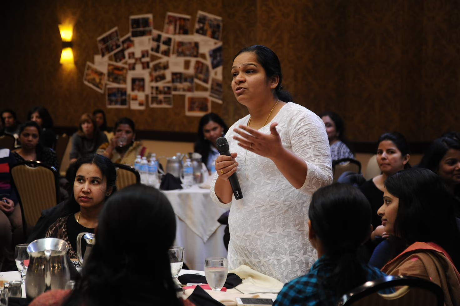 A woman advises the CEO, (out of frame), while he fields questions from the floor, A Celebration of Woman’s Day, Seattle Region, Bellevue, Washington, USA. All the women shown work in high tech as consultants in the US.