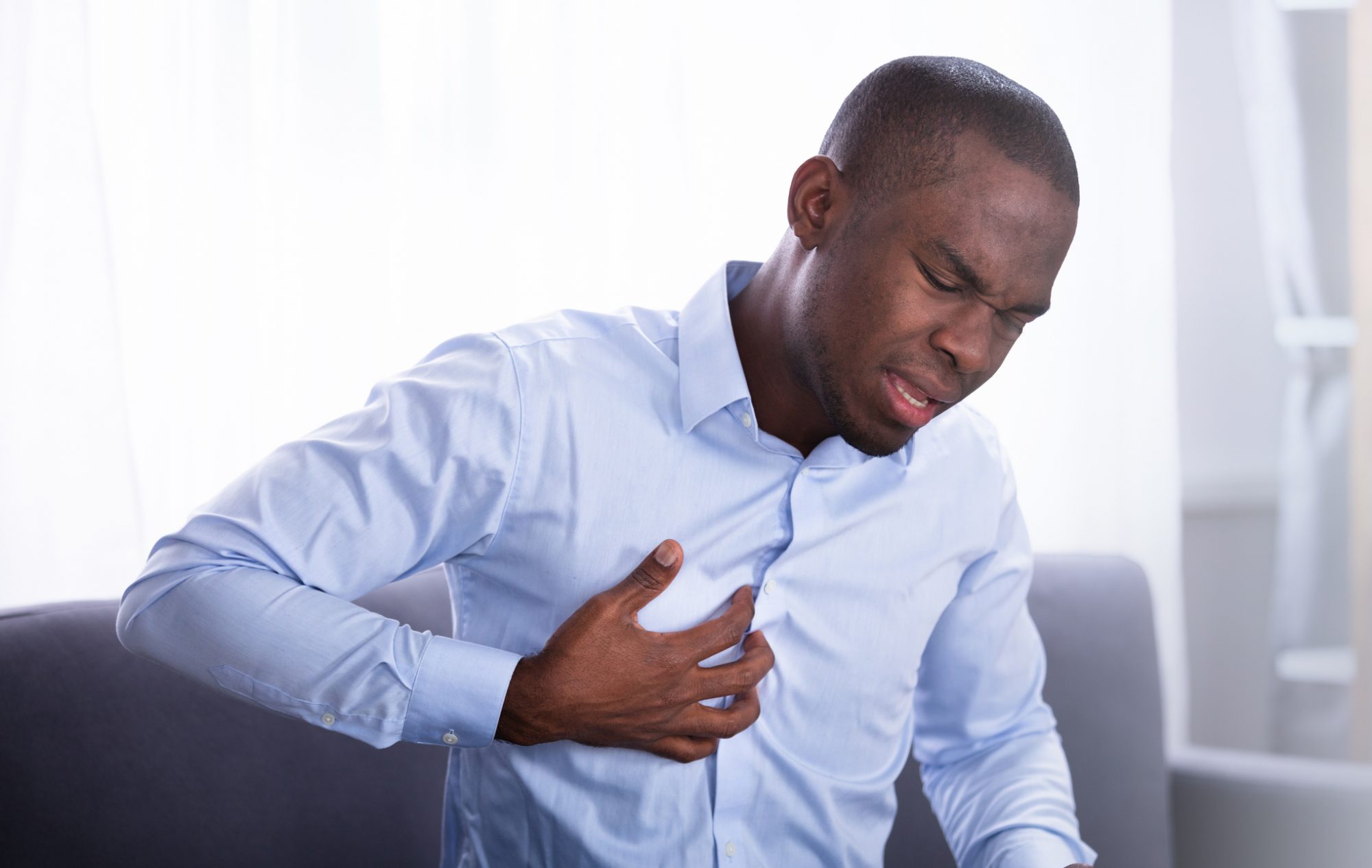 Black man having heart failure clutching his chest