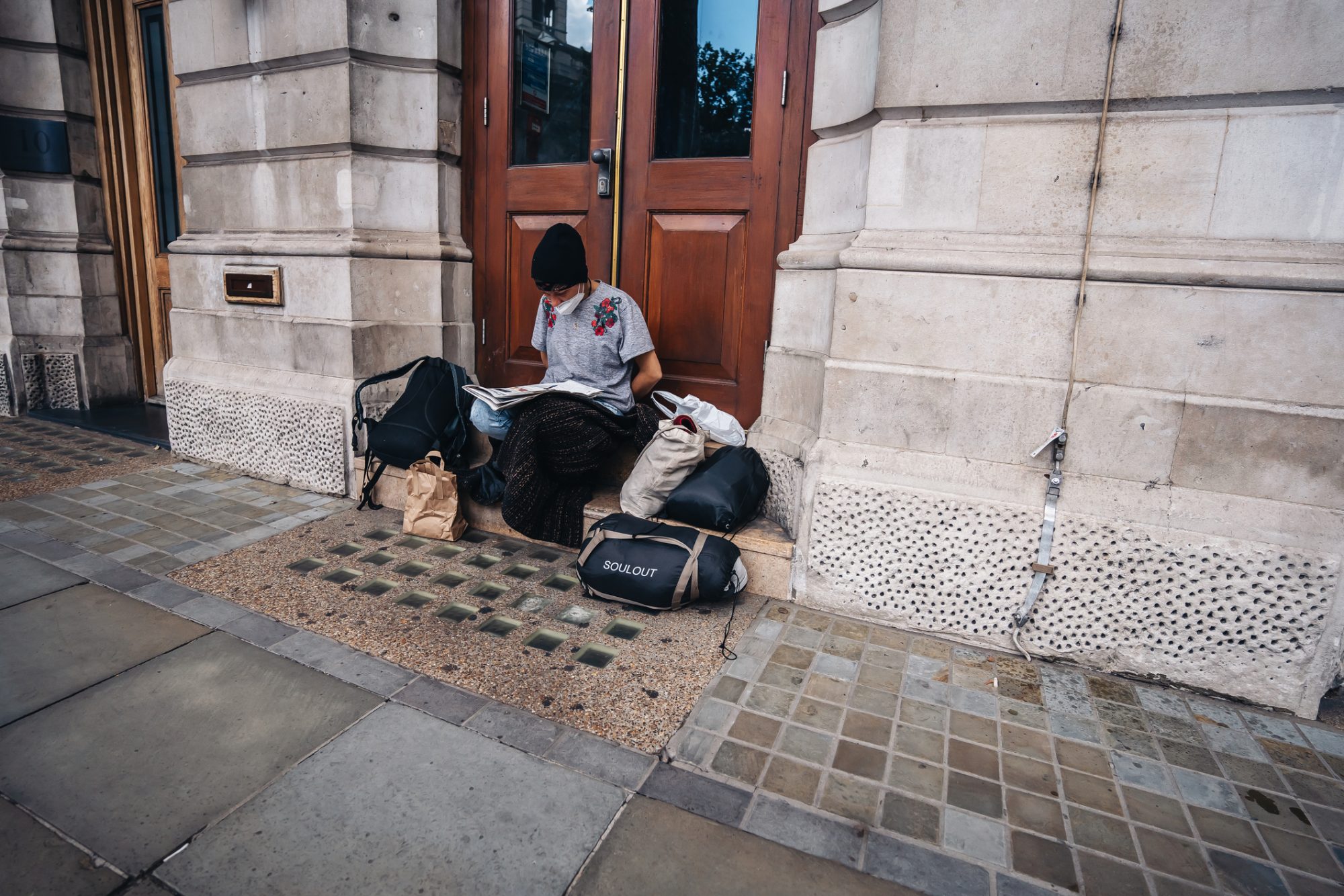 Homeless lady sitting on the pavement in the UK due to housing crisis