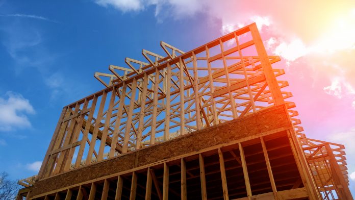 Timber house frame against blue sky