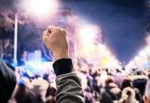 Man holds up fist in solidarity with workers striking