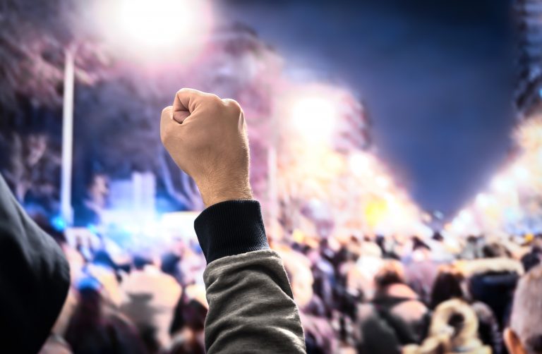 Man holds up fist in solidarity with workers striking