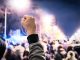 Man holds up fist in solidarity with workers striking