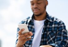 Young black man looks at smartphone