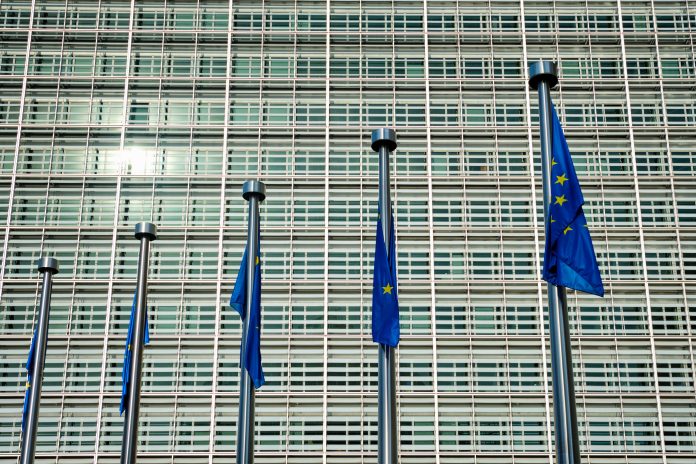 EU European Union flags in front of European Comission building in Background - horizon disagreements