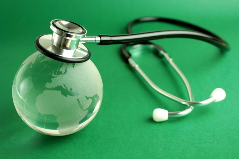 Stethoscope and crystal globe on green background, representing sustainable healthcare