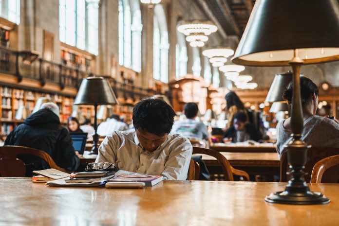 Student tired from thinking and studying in library in New York