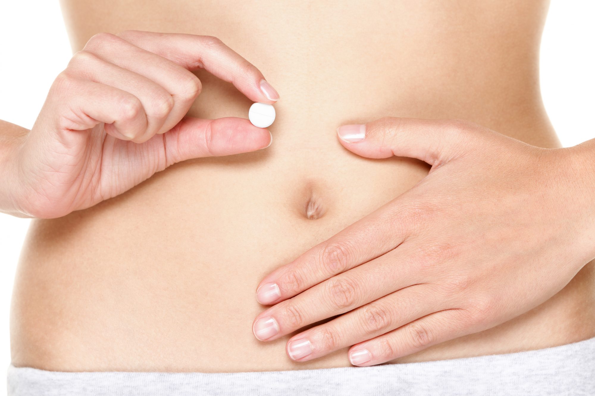 Woman holding stomach and pill to illustrate how body posture and stomach disorders affect oral drug absorption