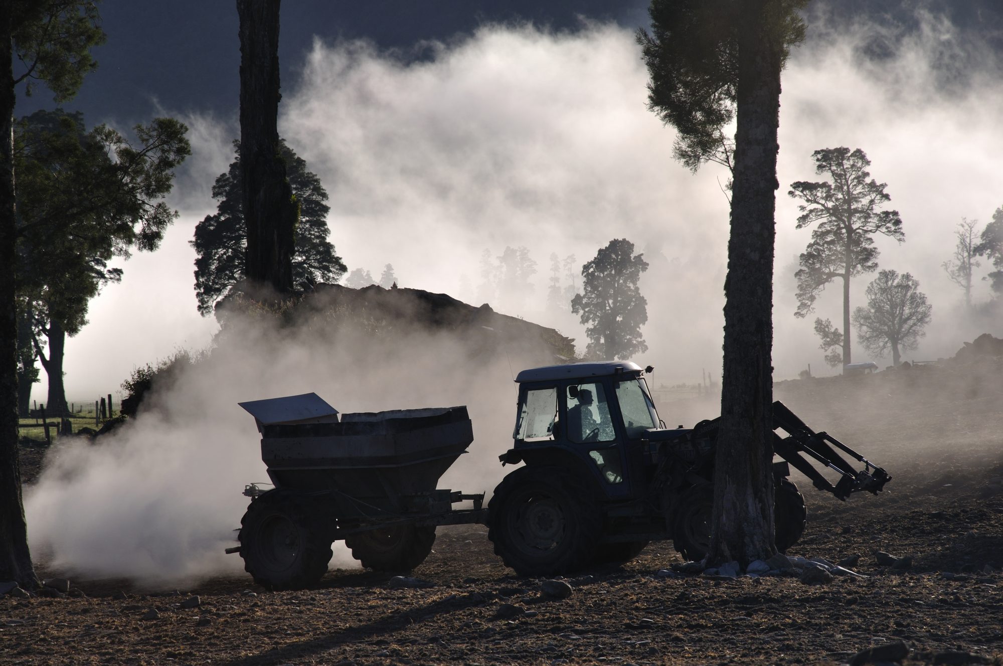 Tractor fertilising a field of cereal crops