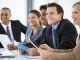 Group Of Business People Listening To Colleague Addressing Office Meeting