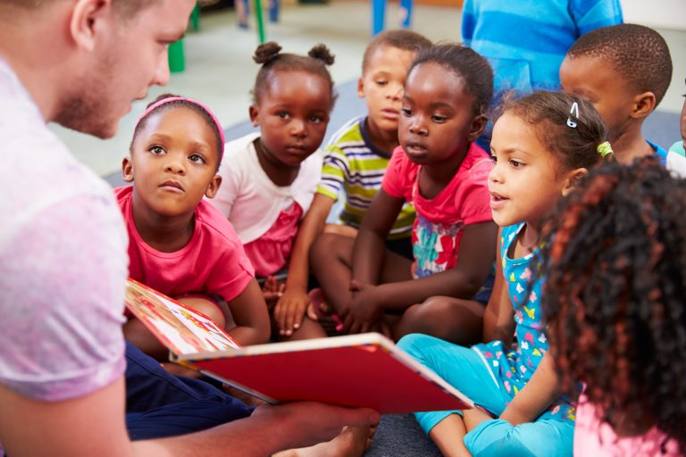 Teacher reading book to class of preschoolers