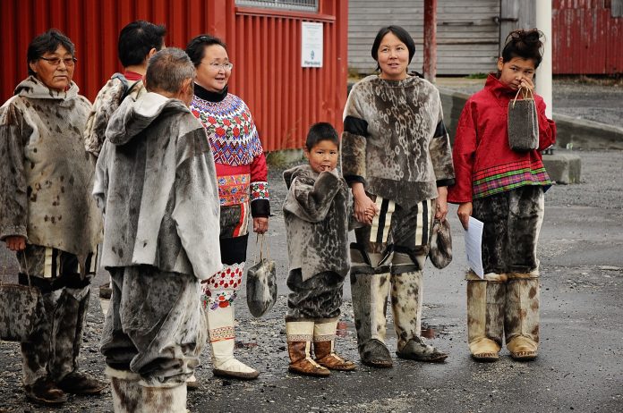 Indigenous Greenland people standing in group in traditional clothing