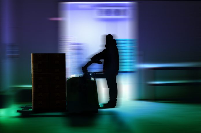 Blurred image showing man working in dark room