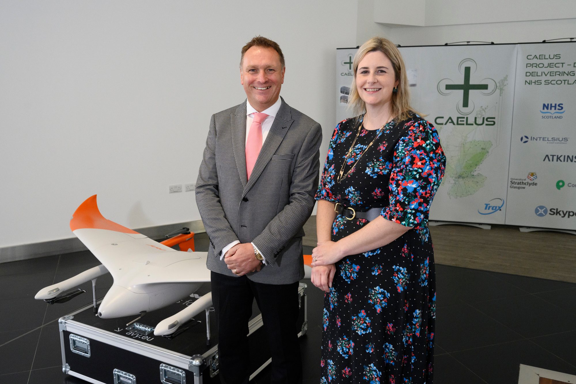 Man and woman stand next to model of medical drone as part of the launch of CAELUS at Glasgow airport Caption: AGS Airports Ltd CEO Derek Provan with Fiona Smith, AGS Group’s Head of Aerodrome Strategy, who is leading the CAELUS project.