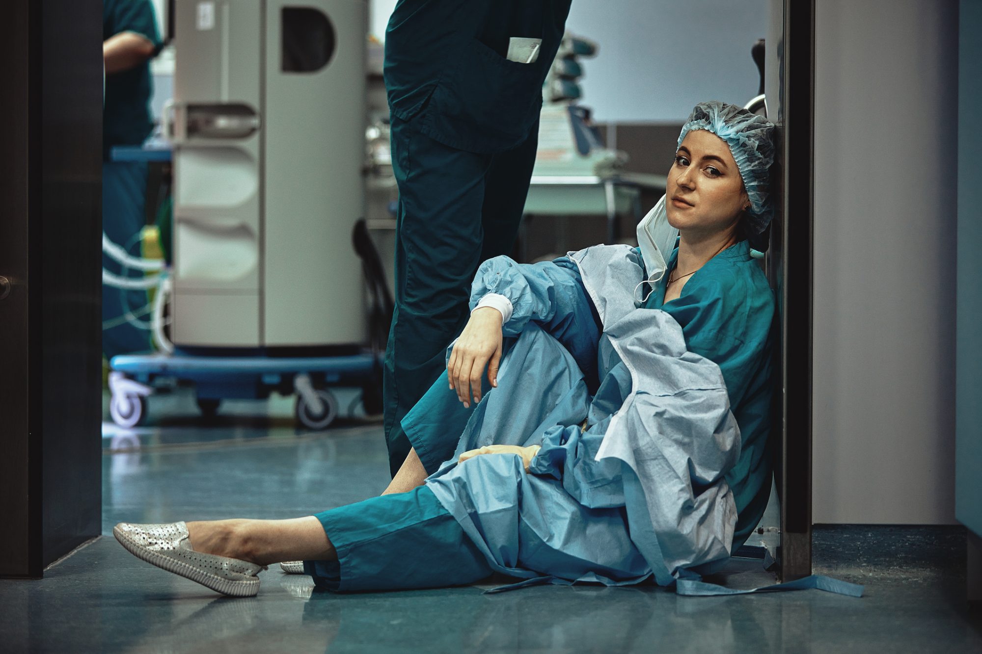 Tired doctor sitting after surgery in the hospital corridor. Great burden on doctors and medicine