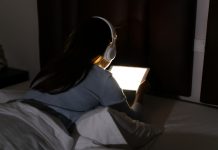 woman up at night with her headphones on not going to sleep