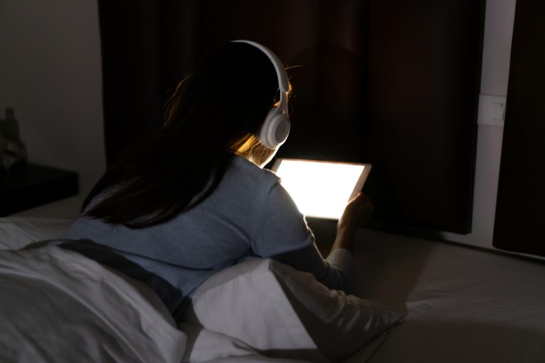 woman up at night with her headphones on not going to sleep