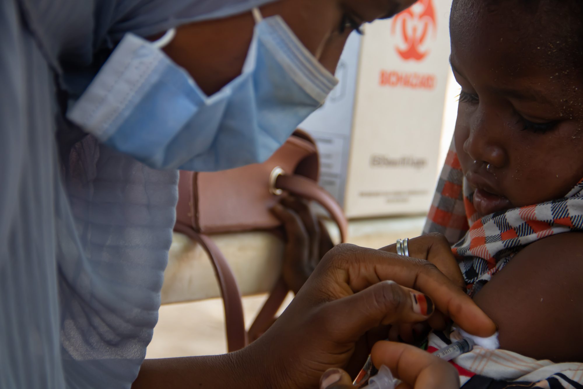 Medical worker doing routine immunization tuberculosis vaccination for children under 9 years, in refugee camp in Africa