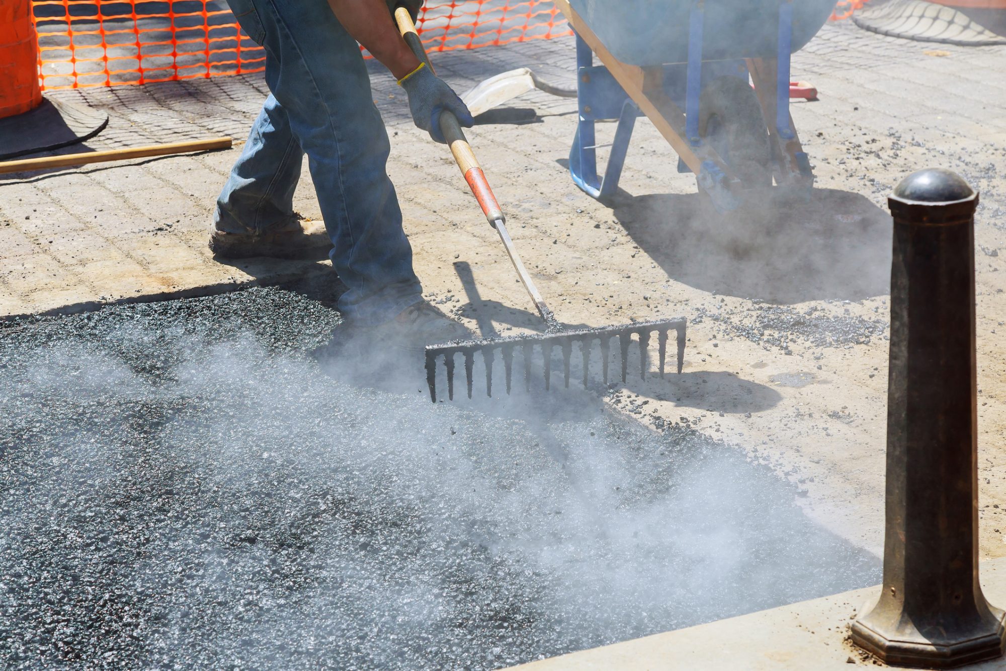 Construction workers during asphalting road works wearing coveralls.