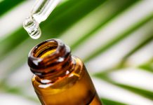 Bottle of CBD and pipette against a green and white background