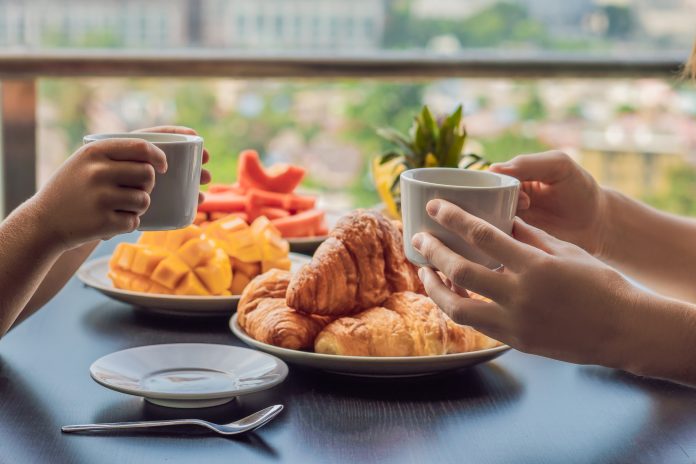 Breakfast table set with croissants and fruit