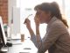 Tired female employee suffer from headache at workplace with long covid brain fog