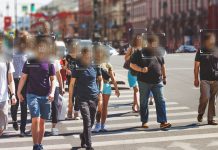 Group of people walking down street with faces blurred