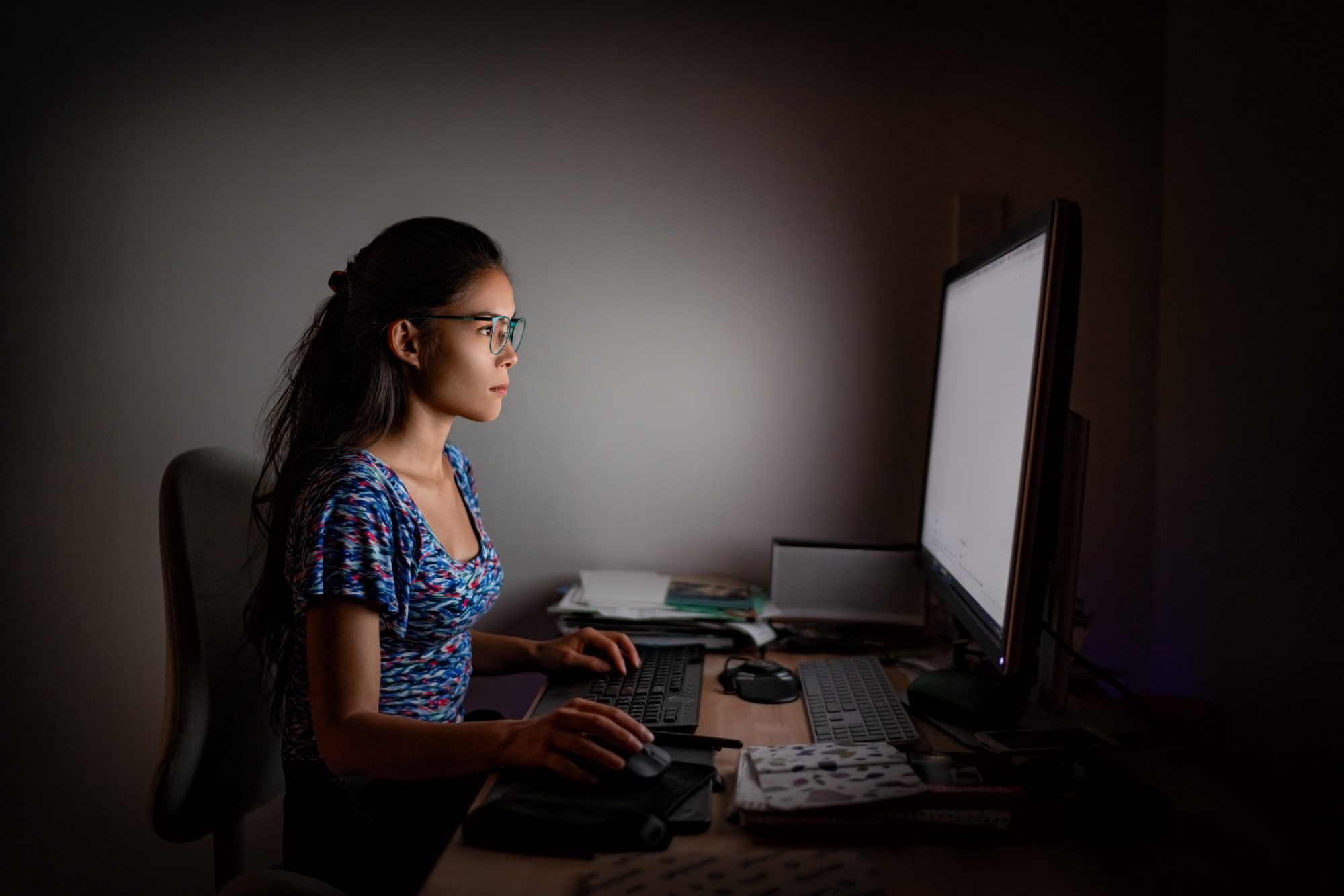 Woman working on computer late at night