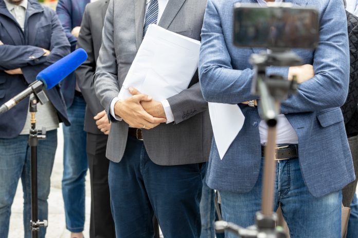 Below head photograph of whistleblowers holding documents