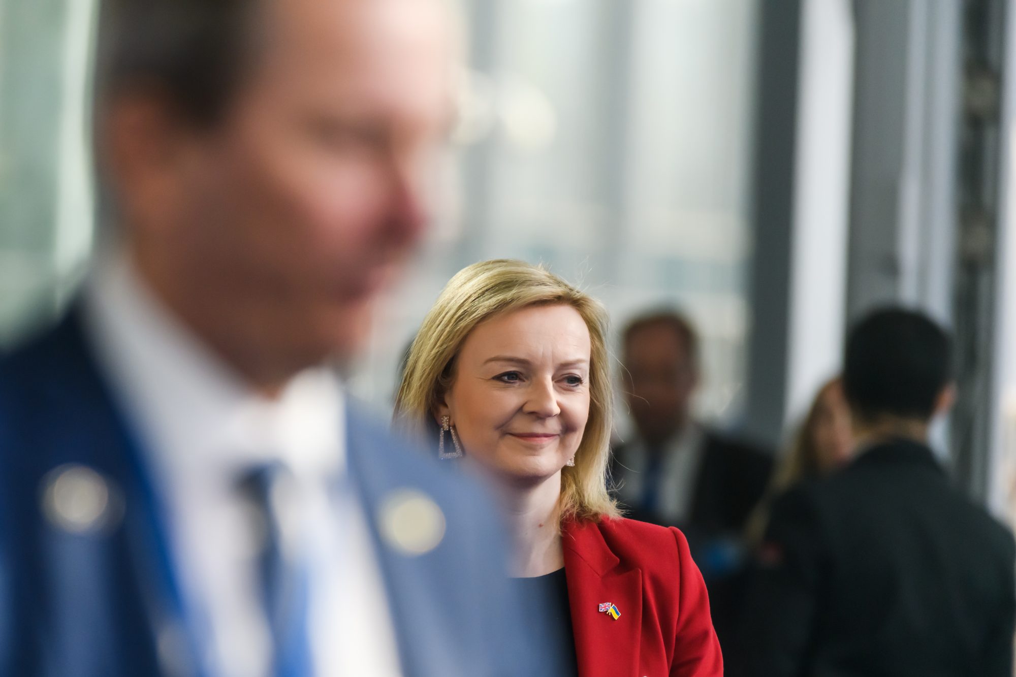 Liz Truss dressed in black top and red blazer jacket