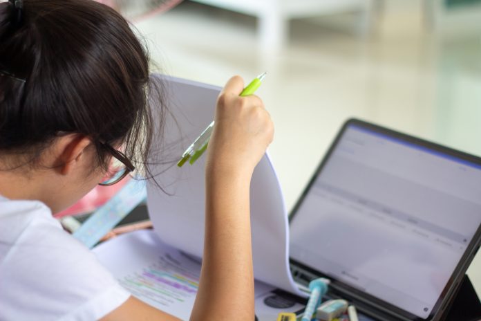 female student taking a digital online exam at school