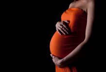 Pregnant woman against a black background